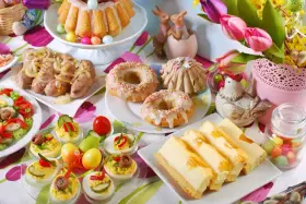 Obfite śniadanie wielkanocne: babka, kiełbaski, jajka faszerowane, sernik i słodkości.